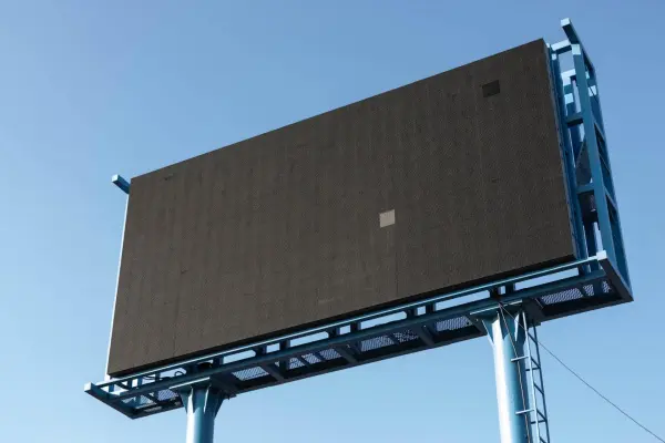 An empty advertising display billboard against a blue sky