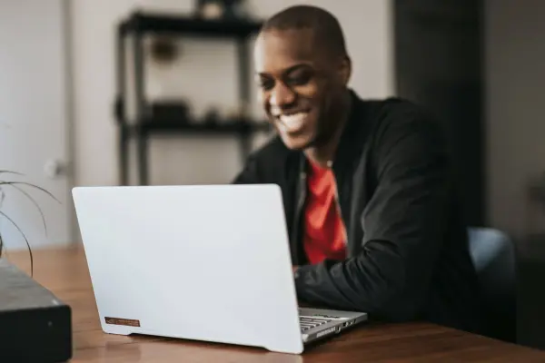 A man views a laptop, happy with the results of his B2B marketing automation cam