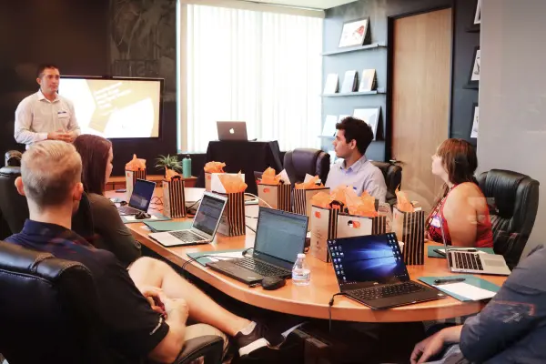 A B2B industrial marketing team sits around a conference table with their laptop