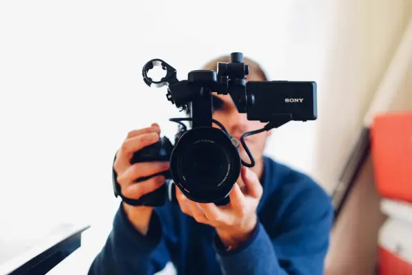 A man holds up a camera to shoot video for a B2B website category page