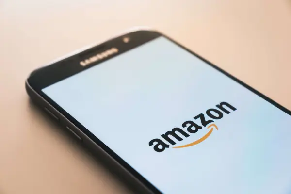 A mobile phone displays the Amazon logo