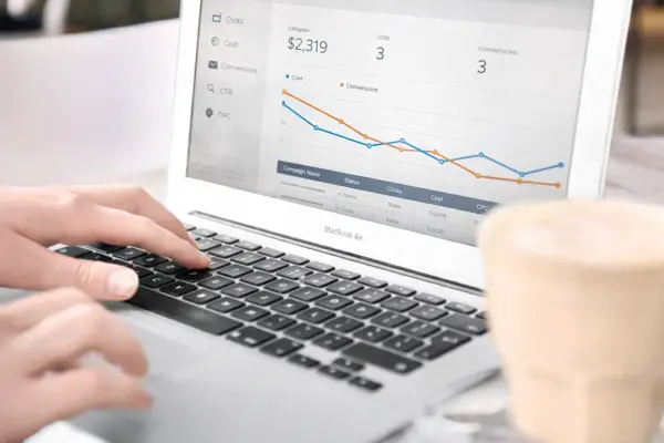 Person reviewing a PPC performance dashboard on a laptop showing ad spend and co