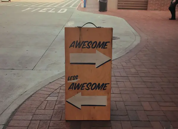 A sign features two arrows, one pointing to the awesome route and one pointing t