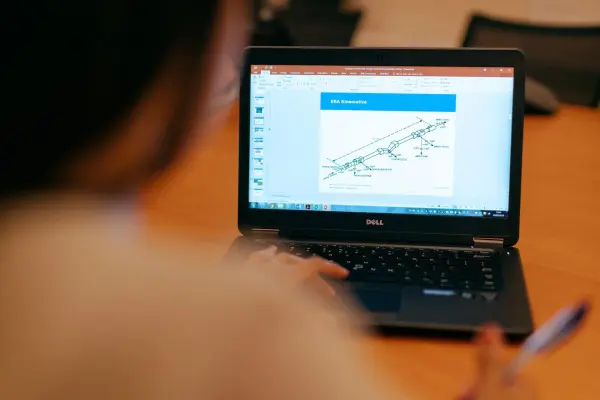 A B2B business owner types on a laptop and plans their custom landing page optim