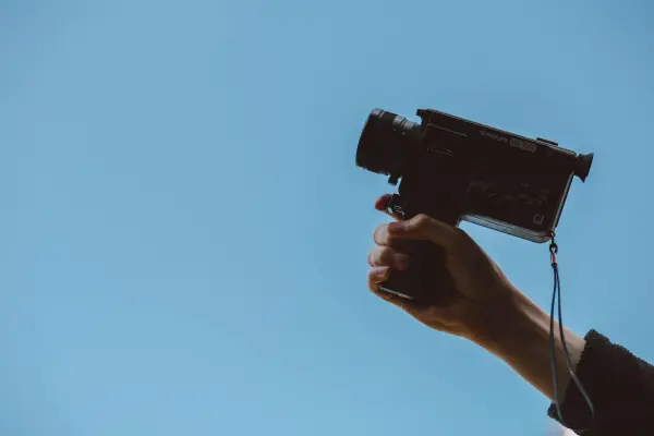 A hand holds up a camera to shoot a video to promote a B2B brand